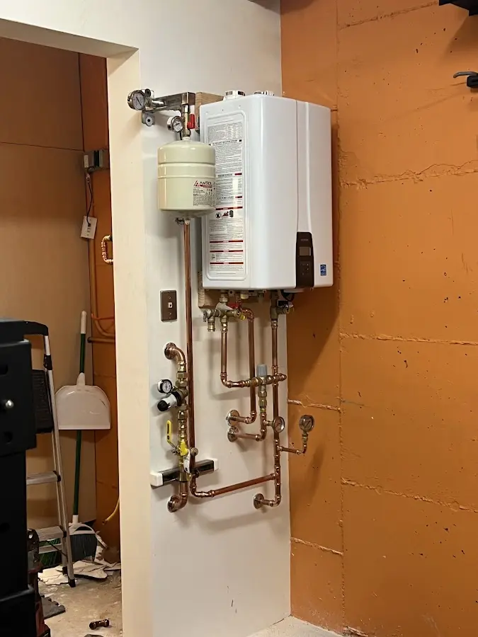 Plumbing technician inspecting water heater connections in Albertville